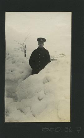 Soldier standing in snow drift after 1916 snowfall, Esquimalt