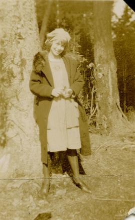 Woman standing next to tree