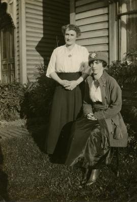 Two women in front of house
