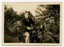 A man in a suit on a motorcycle