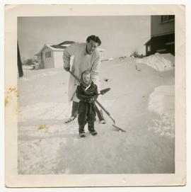Dorothy Dunlop and grandson Geoffrey shovelling snow, 1950