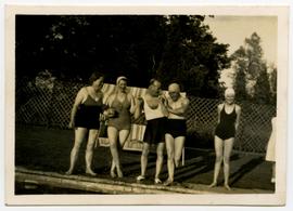 Five people in bathing costumes at a pool