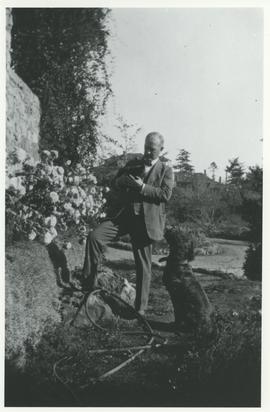 R. H. (Harry) Pooley in garden at "Lyndhurst" with his cat and dog, Bang