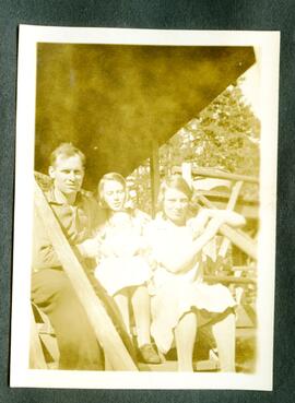 Three individuals sitting on porch