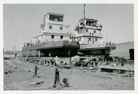 Tugboat under construction alongside another tug, possibly the Prospector