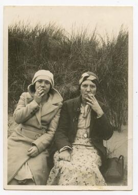 Two women smoking on a beach