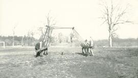 Individuals moving baseball backstop
