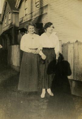 Two women standing by houses