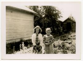Two children standing in a backyard
