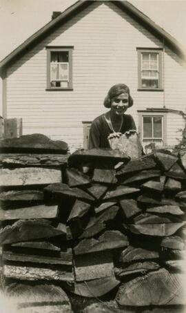 Girl behind wood pile