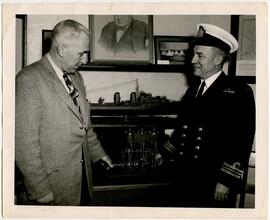 George Armstrong  presenting a model of a triple expansion steam reciprocating engine to Inst. Lt. Cmdr. E. H. Mahon