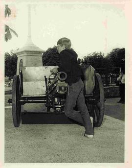 Youth leaning on field gun in Memorial Park