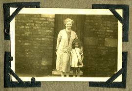 Woman and child in front of a brick wall
